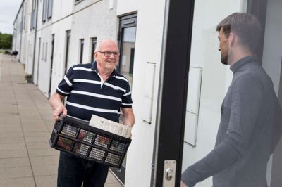 Jens Jørgen Nielsen fra Tjørring har i tre-fire måneder været købmandsbud for Rema 1000. Ordrerne får han på sin mobiltelefon, hvor discountkæden har lanceret en app, der gør det muligt at tilbyde sin hjælp mod betaling uden at være egentlig ansat. På billedet er det Jonas Buus, som modtager sin bestilling. ?Foto: Tom Laursen