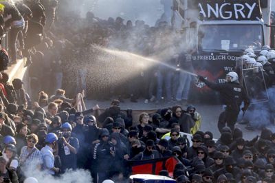 Dåser, flasker og fyrværkeri blev kastet efter tysk politi i Hamburg i forbindelse med G20-topmødet. Politiet svarede igen med vandkanoner og tåregas. /ritzau/AP/Michael Probst