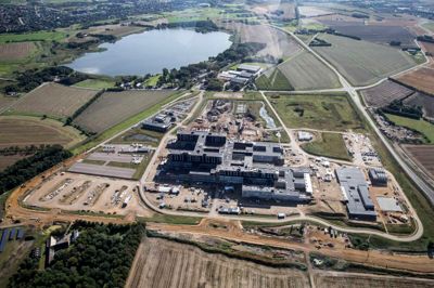 De kommende tvillinge-datacentre ved Regionshospitalet Gødstrup bliver af sikkerhedsgrunde placeret med godt 600 meters afstand i hver sin ende af hospitalsgrunden - henholdsvis på p-pladsen helt mod nord (yderst til venstre på billedet) og ved fjernvarme- og kølecentralen mod syd (helt til højre). ?Foto: Tom Laursen