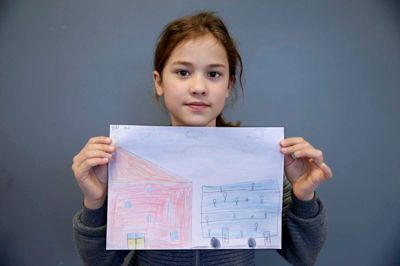Mia, 8 år:
- Jeg har tegnet en bus og et hus. Det er en høj bus. Den er i 10 lag, tror jeg. Der er to indgange, og der er en chauffør, som kører den ved at trykke på en knap. Han skal også sørge for, at folk kommer af. Huset er også stort, fordi jeg tænkte, at det er huse i fremtiden. Men ikke dem allesammen.