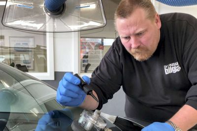 Stenslag repareres ved at skabe undertryk og presse lim ned i »såret«. Her er det Dansk Bilglas' nye afdelingsleder Claus Mikkelsen, der udfører opgaven. Han er netop tiltrådt i jobbet i Herning.?Foto: Bo Lundgaard