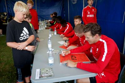 Erik Sviatchenko sætter den sidste autograf på Alexander Hougaard Pedersens plakat, som nu skal hænges op på hans nye værelse i glas og ramme. ?Foto: Flemming Hansen
