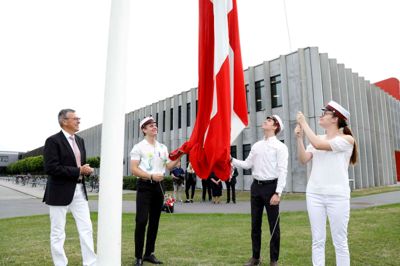 Rektor Søren Brøndum så til, mens Emil Tornøe Jacobsen, Alexander Sangild Nørgaard og Jelena Ninkovic som årets første studenter fik æren af at hejse flaget foran Herning Gymnasium. ? Foto: Henrik Ole Jensen