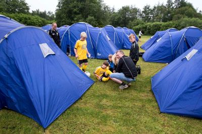 I år skal 1150 børn og unge overnatte på seks forskellige overnatningssteder i Kibæk i forbindelse med Kibæk Cup, hvor der bliver hygget og slappet af mellem kampene i løbet af weekenden. Den nye børnehave bliver taget i brug for første gang, så endnu flere spillere kan samles tæt på banerne, men det er også stadig muligt at sove i telt på pladsen.?Foto: Tom Laursen.