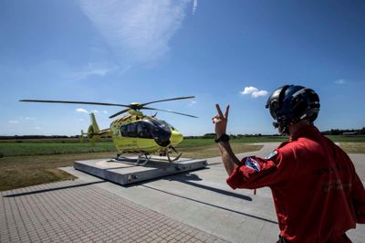 Helikopteren er netop rullet ud af hangaren, og paramediciner Trond N. Fedog giver tegn til piloten, at alt udvendigt er o.k., og motoren derfor må startes op.