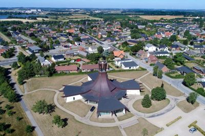 Baunekirken i Tjørring blev indviet i 1977 og er i dag blevet et markant pejlemærke i byens »skyline«. Kirken blev i sin tid bygget, da Tjørrings oprindelige kirke efterhånden var blevet for lille til den voksende by og menighed. I 2012 blev Baunekirken genindviet efter en større renovering på 33 millioner kroner. Her fik blandt andet tagkonstruktionen en kærlig og nødvendig hånd for at imødegå de utætheder, der allerede på indvielsesdagen i 1977 krævede et indkøb af en spand til opsamling af regnvand. Det antal voksede sidenhen til hele 25 spande. Ud over det utætte tag lagde renoveringen yderligere 200 kvadratmeter til kirken, der også fik 13 ton kobber lagt på taget. Baunekirken kan rumme cirka 400 mennesker. Øverst til venstre skimtes byggeriet af DNV Gødstrup.