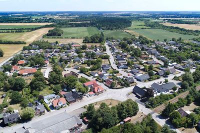 Landsbyen kølkær. Byens torv og rådhus, som beboerne kalder mødestedet med hytte og bålsted, ligger på pladsen nederst ved rundkørslen. Parallelt med hovedgaden løber jernbanen, som dog ikke længere standser i Kølkær. I 1972 blev stationen nedskaleret til et trinbræt, og i 1979 hørte tognene helt op med at standse i byen.