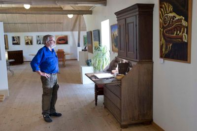 Fotografiet spejler to af Jens Erik Pedersens interesser - kunst og lokalhistorie. På væggene er arbejder af vejlenseren Vagn Bysted. Chatollet, der er fra cirka 1780, har Jens Erik Pedersen hentet på slægtsgården i Velling. Han har haft det skilt totalt ad - og under renoveringen lykkedes det ham at finde chatollets hemmelige rum. Avisens journalist og fotograf blev lokket med en en god flaske rødvin, hvis vi kunne finde rummet. Det kunne vi ikke. ?Foto: Tom Laursen