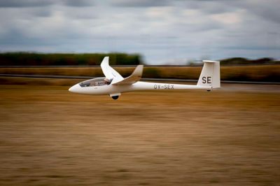 Der er fart på, når svæveflyene kommer ind over den visne landingsbane i Arnborg. Med en sagte hvislen taber flyene langsomt højde, indtil de får kontakt med den store græsmark. Bemærk at alle piloter skal være iført en solhat for at beskytte sig mod solen. ?Foto: Toke Hage