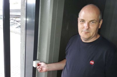 Normalt går skydedøren til DSB-trappetårnet ud mod Godsbanevej automatisk op, når sensorer registrerer bevægelse i nærheden. På højre side inden for døren sidder en »Nødtryk«-knap. Er døren låst, skal den røde knap blot drejes en smule - så popper den ud, og døren fungerer igen. Det er drengestreger, når nogen med vilje blokerer døren i lukket position, mener Ole Poulsen fra DSB Stationsservice. ?Foto: Lars Work Kristensen