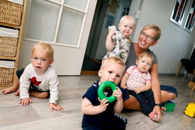 Birthe Brunbjerg Madsen har 25-års jubilæum som dagplejer i Skibbild- Nøvling. Der er netop startet tre nye børn efter sommerferien, så der er gang i hytten. På billedet er det Silas i forgrunden og fra venstre Ida, Lærke og Melika på skødet af Birthe Brunbjerg Madsen. Foto: Henrik Ole Jensen.