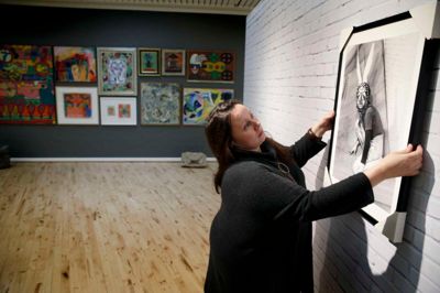 Lotte Korshøj med et fotografi, der skal hænges op på den imiterede murstensvæg - Eugène Brands havde en murstensvæg i sit atelier. ?foto: Flemming Hansen