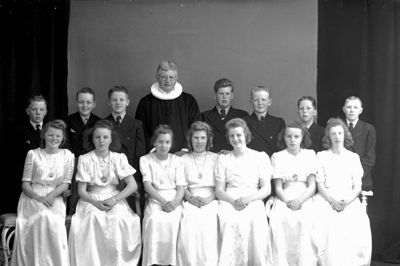 I næste måned er der konfirmation i Ørre Kirke, og præsten hedder Lise Edelberg. For 75 år siden hed præsten Kjeld Lawaetz, han var kommet til kirken i 1935 og ses her sammen med sine konfirmander. ? Foto: Lokalhistorisk Arkiv Herning
