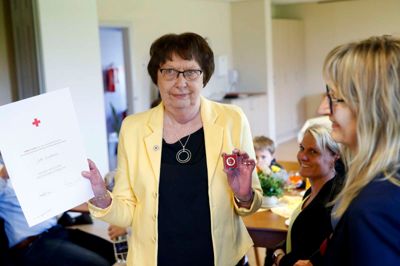På dronningens fødselsdag 16. april fik Jytte Nedergaard Christensen overrakt emblemet og et diplom i Alhuset i Kibæk. Ved sammenkomsten var der medlemmer fra Røde Kors Åskov, familie og venner. Til højre er det formand Tina Poder, og bagved ses datteren Rikke og barnebarnet Oskar på seks år. ?foto: Flemming Hansen