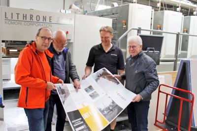 En delegation fra Herning, der har været involveret i processen med den nye bog, var kørt til Skive for at overvære trykstarten på Specialtrykkeriet Arco. Her er det grafisk tilrettelægger Anton Skovbjerg (t.v.), skribenterne Flemming Larsen og Kurt Jørgensen (t.h.) sammen med offsettrykker Jens Gaardsted, der satte hele trykprocessen i gang. I baggrunden til højre ses 3 af de 10 trykværker, der sørger for trykningen. Foto: Leif Hansen/Specialtrykkeriet Arco