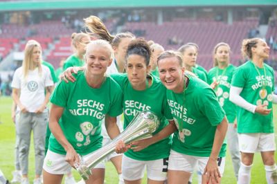Pokaljubel i Wolfsburg-lejren. Pernille Harder (t.v.), Claudia Neto og Kristine Minde stiller op til foto efter finalesejren over Freiburg foran over 17.000 tilskuere i Köln. Wolfsburg har nu vundet »The Double« tre år i træk og den tyske pokaltitel seks gange. ?Foto: Ritzau Scanpix