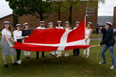 Årets første 13 studenter fra Ikast-Brande Gymnasium sprang ud i bededagsferien. Her er det lykkedes at samle de fleste af dem ved flagstangen, inden Dannebrog sendes til tops. ?Foto: Henrik Ole Jensen