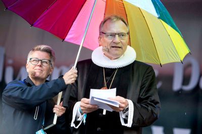Præst ved Baptistkirken på Bornholm, Lone Møller-Hansen, holdt paraplyen for biskop Henrik Stubkjær fra Viborg Stift, da han stod for prædiken under åbningsgudstjenesten ved Himmelske Dage på Heden. ?Foto: Tom Laursen