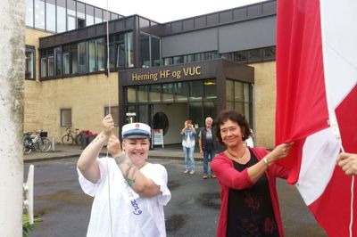Trine Irene Hansen sluttede med 10 i mundtlig matematik og blev årets første student hos Herning HF & VUC. Hun hejste flaget sammen med rektor Anne Vandsø Madsen. Om aftenen kunne Trine Irene Hansen lufte huen sammen med familien på restaurant »Ravello«. foto: jesper wind Jesper Wind
