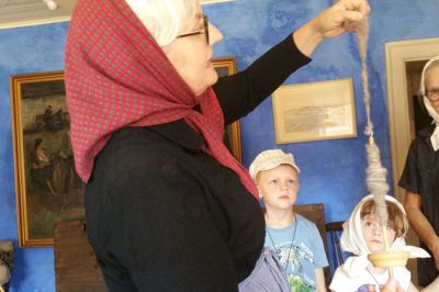 Grethe Christensen i sort kjole stod for rejsen tilbage i tiden på Bundsbæk Mølle. Christian og Caroline ser sammen med mormor Thora Nordestgaard, hvordan man spandt uld tilbage i midten af 1800-tallet. foto: jesper wind Jesper Wind