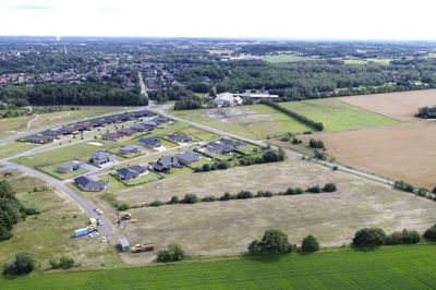 Der er nu taget hul på udvidelsen af Brande, som over de næste årtier vil finde sted i den sydlige del af byen. Der er udtænkt en grundig sammenhæng mellem natur og boliger. Dronefotoet viser Delområde A med tilnavnet »Skoven«, hvori den første klynge med 13 grunde - som ligger i forlængelse af boligerne på Ny Sandfeldvej - snart er klar til salg. Striben af buske midt på udstykningen skjuler en afvandingskanal, som bliver slynget gennem det grønne fællesområde midt i boligklyngen. Rideklubben får lov til at beholde sine græsfolde midt i billedet, mens kornmarkerne til højre bliver dækket med træer og andre boligklynger. Foto: Tom Laursen