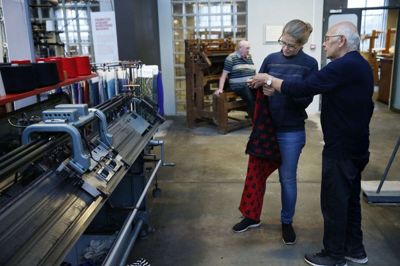 Kristian Willumsen viser det nye babytæppe til Kristine Holm-Jensen, mens »Strømpe-Christian« Nielsen tager sig et hvil i baggrunden. Foto: Flemming Hansen