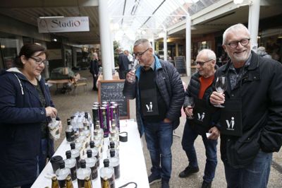 Ikast Vinfestival bød i år også på specialiteter fra Peru. Her er det Carolina Nava, der serverer gin for Poul Heine, Bjarne Fenger og Jørn Carlsen. Foto: Flemming Hansen