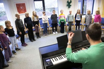 Spirekoret og Thomas Bach Madsen varmer stemmerne op inden dagens sang. Foto: Tom Laursen