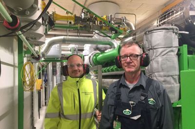En af de folk, der sørger for kraftvarmeværket, er smeden Aksel Dam (t.h.) - her sammen med vedligeholdelseschef Christian Hornstrup ved af de to motorer. Foto: Ole Skydt