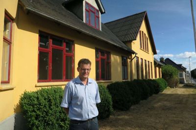 Ronni Jensen, bestyrelsesmedlem i Udviklingsselskabet Fasterholt ApS, foran selskabets seneste køb. Det tidligere mejeri, der gennem mange år var en kommunal institution, er i dag ombygget til lejligheder og fuldt udlejet. foto: jesper wind