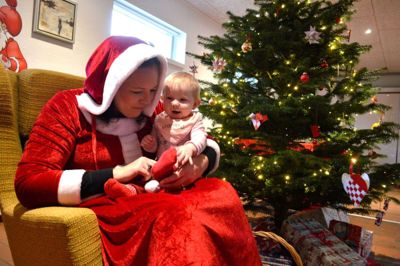 Julemor tog imod børnene og lyttede til årets juleønsker. 10 måneder gamle Mika Sønderskov Klausen lod sig ikke skræmme af den røde dame. F oto: Laila Kempel