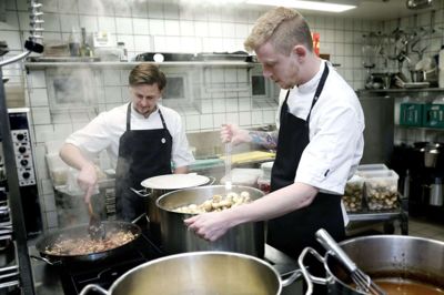 Jeff Wallentin (t.h.) og Lucas Hartmann ved gryderne på Skarrildhus. Begge er i lære som kokkeelever, og til elevaftenen næste fredag har de udarbejdet en menu ud fra temaet Skarrildhus’ historie. foto: Henrik OLe Jensen