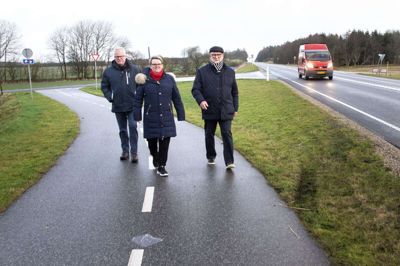 Cykelstien fra rundkørslen i Kibæk og op til Velhustedvej bliver primært brugt som motionssti af de lokale, siger Knud Nielsen (t.h.) fra Kibæk Lokalråd. - Når de når hertil, så spejder de længelsesfuldt mod nord. Men de kan ikke komme længere ad cykelstien, siger han om den befærdede Vardevej, som nærmest ingen tør cykle på, fordi det er med livet som indsats. Sammen med blandt andre byrådsmedlem Vinnie Borbjerg og Poul Bech (t.v.) kæmper lokalrådet for at få cykelstien forlænget. foto: Tom Laursen