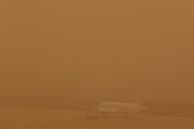 Kan du få øje på flyet? Den kraftige sandstorm gjorde det næsten umuligt at lette og lande i lufthavnen i weekenden. Foto: Borja Suarez/Reuters
