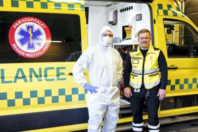 Ambulanceredderne Kenneth Damholdt - gemt under overtræksdragten - og Christian Aaskov iklæder sig værnemidler, når de skal ind til en patient, hvor der er mistanke om covid-19. Foto: Hans Christian Strikert
