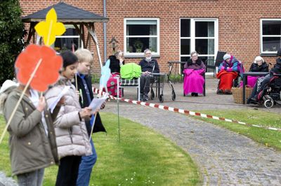 18. marts blev der indført forbud mod indendørs besøg på alle plejecentre i Ikast-Brande Kommune for at beskytte de ældre beboere mod coronasmitte. For at muntre de ældre op midt i den ensomme hverdag fik nogle elever den idé at synge for beboerne. Således troppede 70 elever fra 4. årgang på Østre Skole og deres medfølgende lærere - efter aftale med Rolighedsparkens personale - op onsdag og berigede formiddagen med fællessang. Foto: Tom Laursen