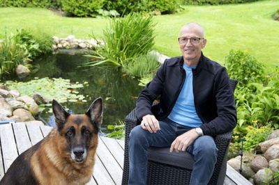 Bjarne Møller Pedersen er fascineret af vand og etablerede en havedam ved hjemmet i Kibæk for seks år siden. Dammen er på cirka 25.000 liter og med en dybde på op til halvanden meter. Han trækker også selv i våddragt og dykkerbriller, når dammen skal renses. På billedet ses han med schæferen Pontiac - opkaldt efter den amerikanske bil af samme navn. Foto: Tom Laursen