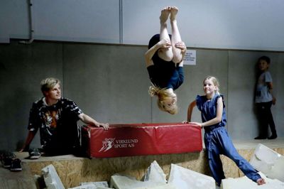 Instruktør Peter Rostgaard guider børnene i spring både på måtter, på baner og i springgrav. Her er det Naia Lundsberg Kristensen (med hovedet nedad) og Emily Christensen, der lærer nye tricks. Foto: Henrik Ole Jensen