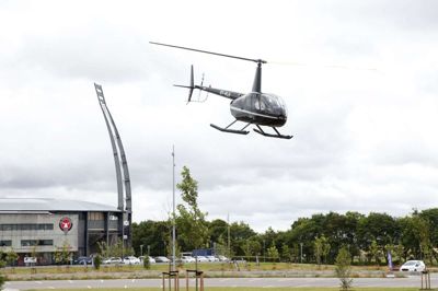 Pilot Christian Lilholt fra Herning Helicopters letter fra parkeringspladsen foran MCH Arena med eventkoordinator Nicolai Houe fra FC Midtjylland ombord. Foto: Tom Laursen