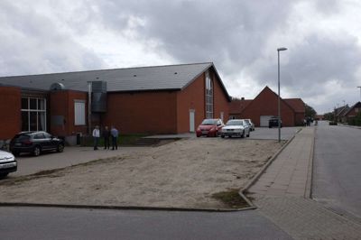FØR: Pladsen foran Sjørring Idræts- og Kulturcenter var en noget trøstesløs størrelse, før Cronhammar tog over - han ses i øvrigt med hvid skjorte og seler. Foto: Leif Sørensen