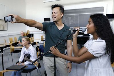 Camille Leerhøy (siddende) og Julia Arulanandam synger, mens Chris Minh Doky er ved at lave en video, som han sender til Martin Brygmann. Foto: Henrik Ole Jensen