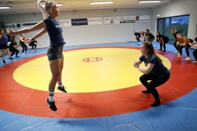 Mille Damberg Würtz (t.v.) og Nanna Andersen viser såkaldte squat jumps, mens hele deres hold af »Dejlige Damer« følger trænernes eksempel. Foto: Flemming Hansen