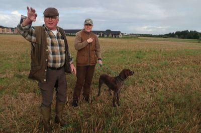 Laila Bilberg har sin korthårede hønsehund, Ginger, til markprøve. Knud Maabjerg fortæller, hvad han vil have jægere og hunde til, inden de bliver sluppet løs to og to ud over marken. foto: Henrik Lind Jørgensen