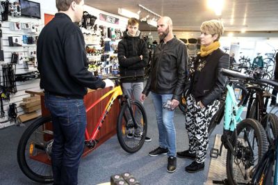 Thomas Kousgaard er ved at afslutte salget af tre mountainbikes til familien Mogensen. Det er Simon, Ole og Maggi Mogensen, som nu skal til at cykle i fællesskab. Foto: Tom Laursen