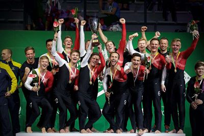 Kristoffer Hayes (nummer 9) er en af de mest rutinerede TeamGym-gymnaster i Danmark og skal endnu engang forsvare det danske guld til EM i 2021 på hjemmebane. Her ses han med herrelandsholdet efter EM-guldsejren i 2018. Foto: GymDanmark