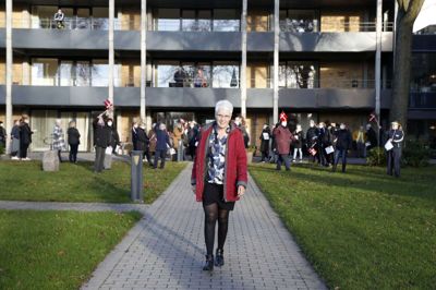 Efter 40 år som sygeplejerske - de seneste 17 som centerleder på Vesterled - går Ruth Johannesen på efterløn. Gennem alle årene på plejecentret har hun blandt andet været bannerfører for festlige stunder for beboere, pårørende og personale. Men på hendes egen sidste arbejdsdag, fredag, var der ikke mulighed for at holde fest på grund af coroan-restriktioner. I stedet overraskede nuværende og tidligere kollegaer med sang i solen. Foto: Flemming Hansen