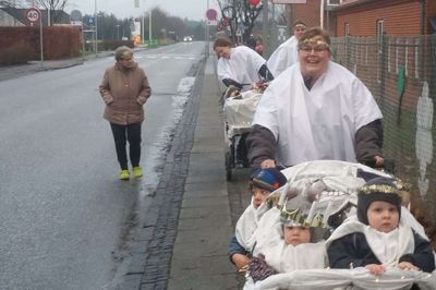 Pædagog Dorthe Kristensen førte an i onsdagens luciaoptog gennem Troldhede. 10 børn fra vuggestuen i Troldhede Børnehus ville på afstand bære lyset ind. Ellie i forreste vogn med krone var luciabrud. Foto: Jesper Wind