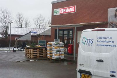Kunders biler er afløst af biler fra SSG Skadeservice, der er ved at slette sporene efter en mus hos Min Købmand i Troldhede. Købmand Mathias Kristensen regner med, at han tidligst kan åbne tirsdag i næste uge. Foto: Jesper Wind