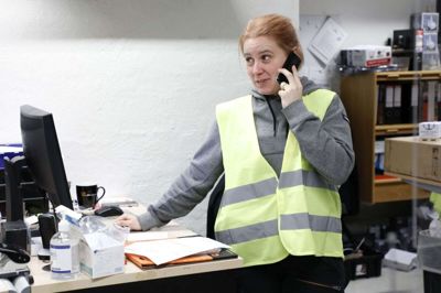 Salgsassistent Mette Amstrup bruger meget tid på at rådgive og vejlede kunder i telefonen. Den gule vest viser, at hun er butikkens coronavagt - også selv om der ikke er mange kunder at vogte over. Foto: Henrik Ole Jensen