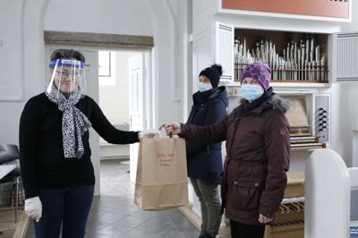 Jette Smed i den lilla frakke og bag hende Jette Thuesen var de første til at tage mod posen med ting til fastelavn, som sognene Troldhede, Nr. Vium og Herborg tirsdag delte ud. Kirke- og kulturmedarbejder Helle Boel havde fået idéen. Foto: Henrik Ole Jensen